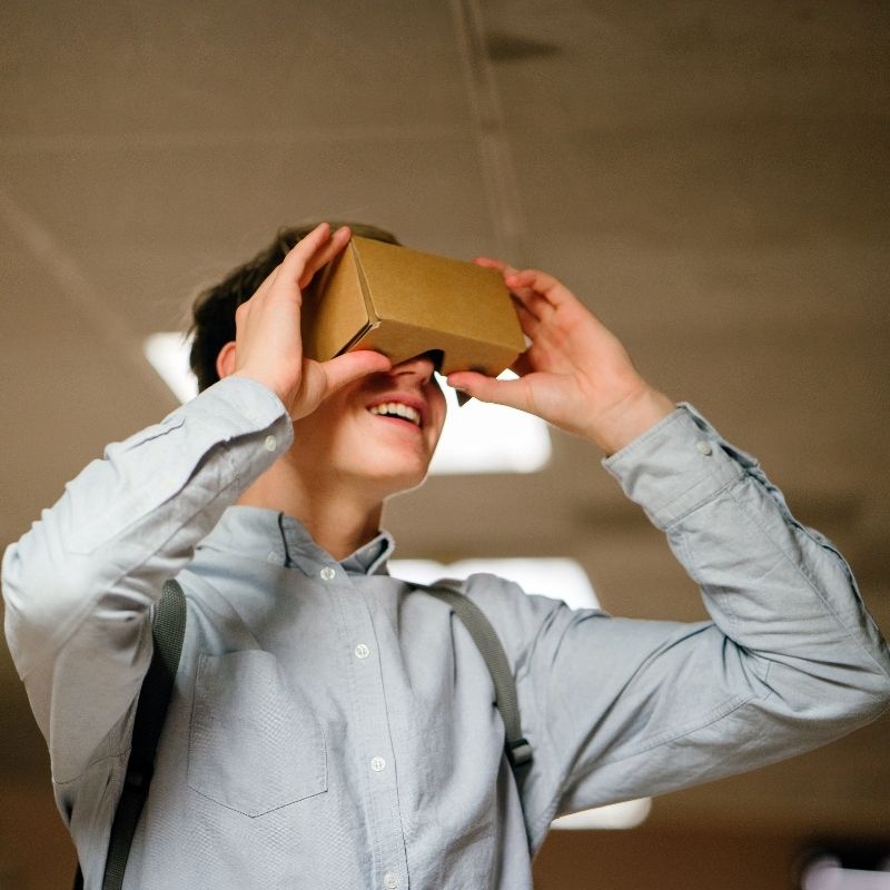 Person Wearing a Cardboard Vr Headset and Smiling Indoors Exploring Virtual Reality